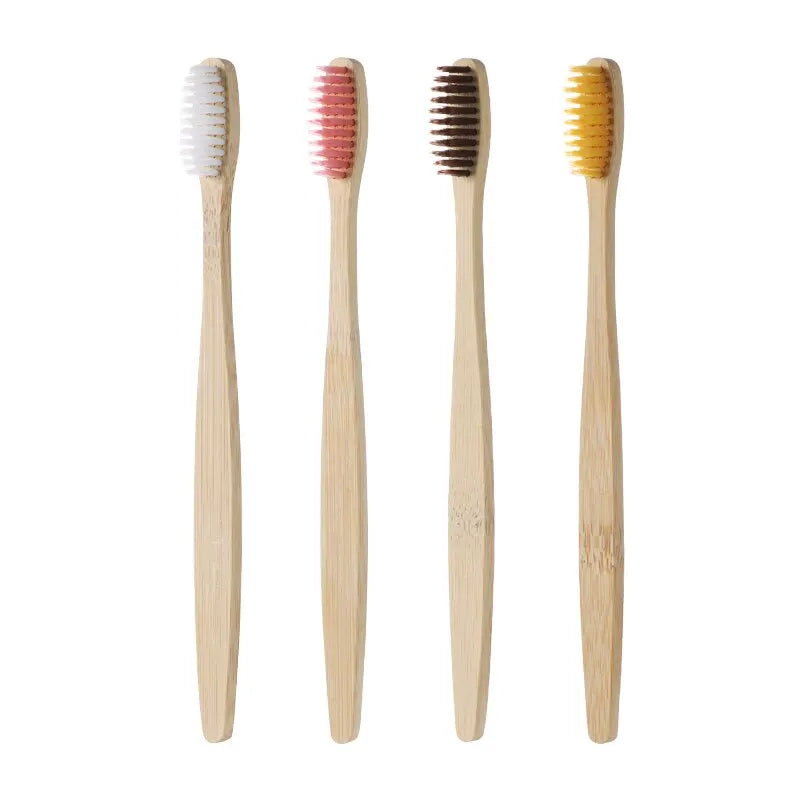 Quatre brosses à dents en bambou aux poils blanc, rose, brun et jaune, sur fond blanc
