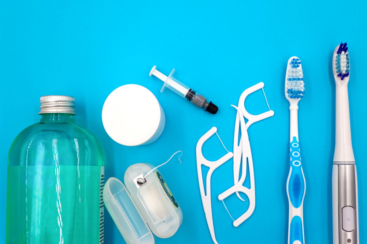 Essentiels d'hygiène bucco-dentaire posés à plat, illustration du choix entre fluor et hydroxyapatite