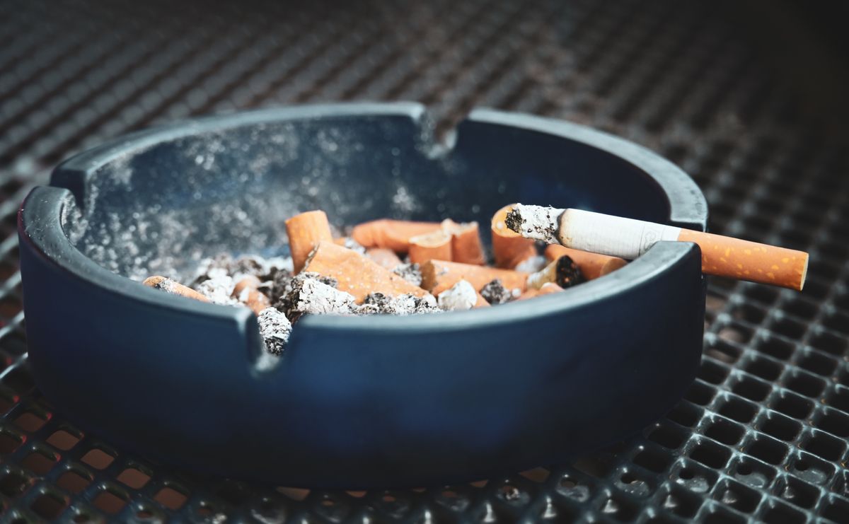 Cigarette posée sur un rebord, symbole du tabac et de ses effets sur les gencives