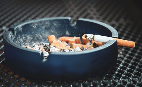 Cigarette posée sur un rebord, symbole du tabac et de ses effets sur les gencives