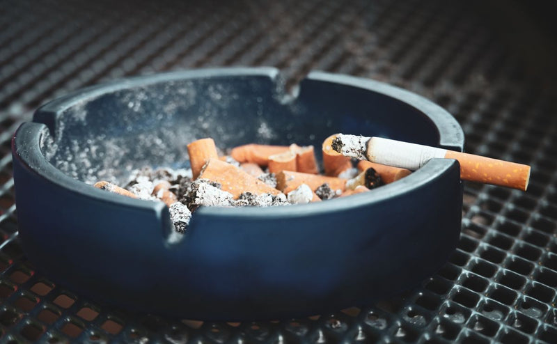 Cigarette posée sur un rebord, symbole du tabac et de ses effets sur les gencives