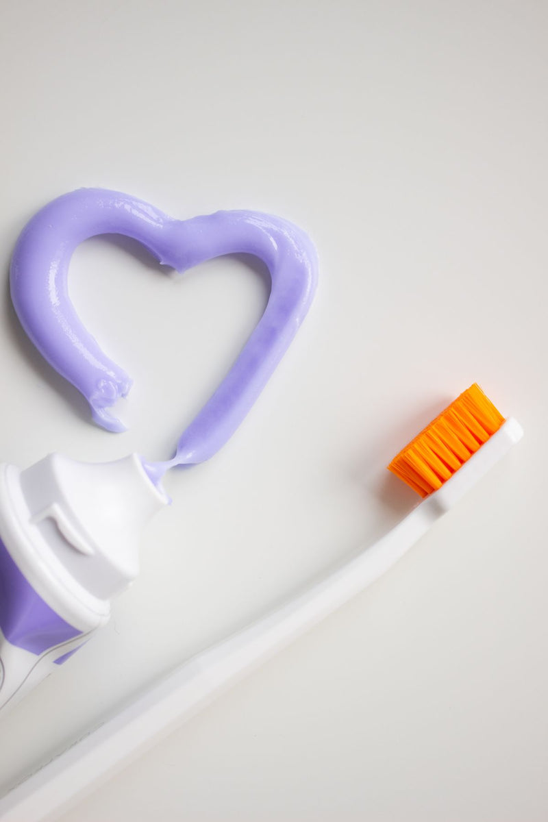 Dentifrice violet déposé sur une brosse à dents, la tendance virale du sourire « instantanément » plus blanc