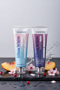 Pack Duo Ultra White ÉclatDent : les deux dentifrices sur une ardoise humide avec pêche, grenade et fleurs de cerisier