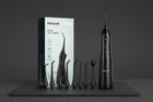 Hydropulseur Oral Haute Performance 5020E ÉclatDent : L'hydropulseur et ses embouts sur une ardoise noire, fond sombre