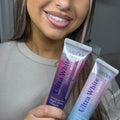 Femme souriante tenant les deux dentifrices du Pack Duo Ultra White Pêche & Grenade ÉclatDent