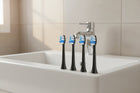 Brossettes de rechange ÉclatDent : Les brossettes de rechange au bord d'un lavabo de salle de bain