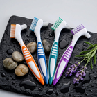 Cleaning brush for aligners and retainers — on a wet black slate with pebbles and lavender