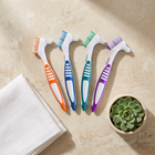 Cleaning brush for aligners and retainers — flat lay on a cream background, minimalist composition