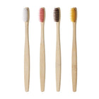Quatre brosses à dents en bambou aux poils blanc, rose, brun et jaune, sur fond blanc