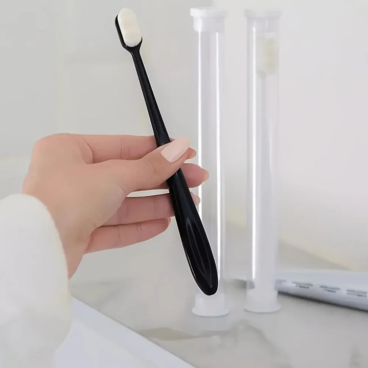 Brosse à dents ultra-souple à manche noir dans une salle de bain claire