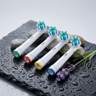 Testine compatibili Oral-B a setole incrociate — su ardesia nera bagnata con ciottoli e lavanda