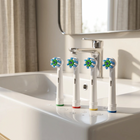 Testine compatibili Oral-B a setole incrociate — sul bordo di un lavabo bianco, luce del mattino