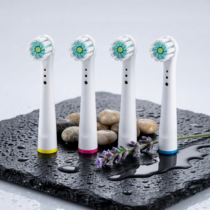 Testine compatibili Oral-B con ciuffo centrale — su ardesia nera bagnata con ciottoli e lavanda