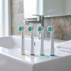 Testine compatibili Oral-B con ciuffo centrale — sul bordo di un lavabo bianco, luce del mattino