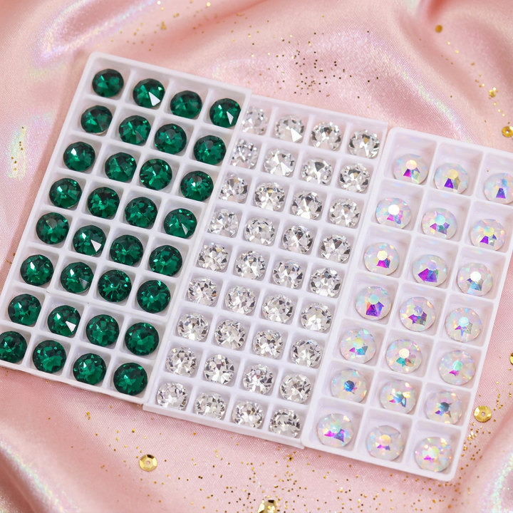 Brillantes dentales de cristal — sobre satén rosa empolvado con reflejos irisados