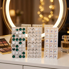 Strass dentaires en cristal à dos plat — sur une coiffeuse devant un miroir éclairé