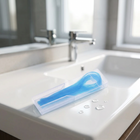 Floss threaders — on the edge of a white washbasin, morning light