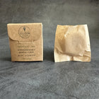 Boîte de fil dentaire en carton à côté d’un sachet en papier kraft