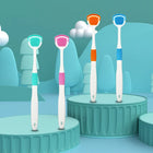 Quatre nettoyeurs de langue souples, vert, rose, orange et bleu, debout sur des socles