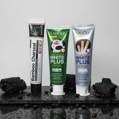 Pack Expert Anti-Taches ÉclatDent : les trois dentifrices sur une ardoise humide avec grains de café et charbon