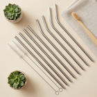 Reusable stainless steel straws — flat lay on a cream background, minimalist composition