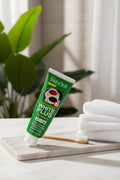 Dentifrice Anti-Taches Café ÉclatDent sur un plateau de marbre avec une brosse à dents en bambou