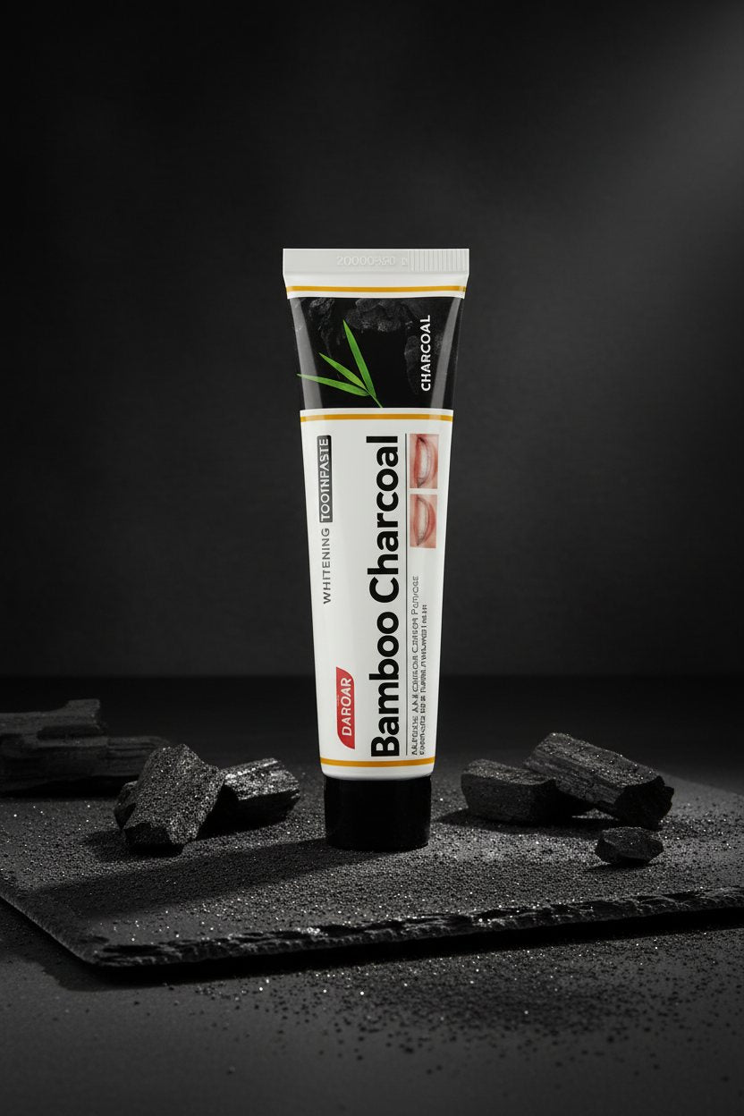 Dentifrice Charbon Actif Blancheur ÉclatDent sur une ardoise noire entouré de morceaux de charbon