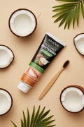 Dentifrice Blancheur Douceur Coco ÉclatDent vu de dessus avec noix de coco et feuilles de palmier