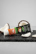 Dentifrice Blancheur Douceur Coco ÉclatDent sur une ardoise humide avec des morceaux de noix de coco