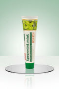 Dentifrice Classique Menthe ÉclatDent sur un socle réfléchissant, fond studio vert dégradé
