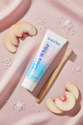 Dentifrice Pêche & Sel Marin ÉclatDent vu de dessus avec quartiers de pêche et cristaux de sel