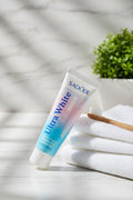 Dentifrice Pêche & Sel Marin ÉclatDent sur un plateau de marbre avec une brosse à dents en bambou