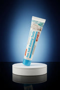 Dentifrice Sel Marin & Bicarbonate ÉclatDent sur un socle rond, fond studio bleu nuit