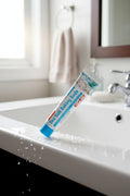 Dentifrice Sel Marin & Bicarbonate ÉclatDent posé au bord d'un lavabo de salle de bain