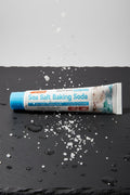Dentifrice Sel Marin & Bicarbonate ÉclatDent sur une ardoise humide avec des cristaux de sel marin