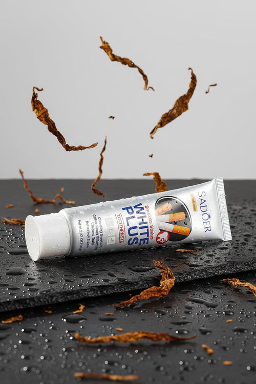 Dentifrice Anti-Taches Tabac ÉclatDent sur une ardoise humide avec des feuilles de tabac séchées