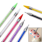 Stylos à cire montrant leurs deux bouts, embout cire et pointe métallique fine, avec en médaillon la pointe utilisée sur un ongle