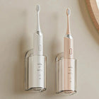 Two clear wall holders, each holding an electric toothbrush upright
