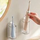 Electric toothbrush being placed in a clear holder stuck to the wall