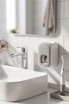Distributeur de dentifrice mural — au bord d'un lavabo blanc, lumière du matin