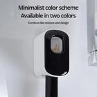 Dispenser di dentifricio con frontale nero fissato alla parete del bagno