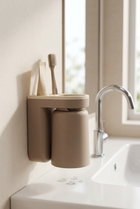 Support mural brosse à dents — au bord d'un lavabo blanc, lumière du matin