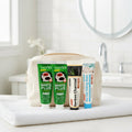 Pack Caffè-Dipendente — 4 dentifrici ÉclatDent: i quattro tubetti riposti in un beauty case beige su un asciugamano bianco