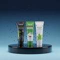 Pack Splendore Carbone — 4 dentifrici ÉclatDent: i quattro tubetti su un piedistallo rotondo lucido, sfondo studio blu sfumato