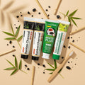 Pack Splendore Carbone — 4 dentifrici ÉclatDent visto dall'alto su sfondo beige: i quattro tubetti circondati da pezzi di carbone attivo e steli di bambù