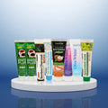 Complete Collection Pack — 8 toothpastes ÉclatDent: the eight tubes on a glossy round pedestal, blue gradient studio background
