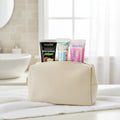 Pack Gengive & Dolcezza — 3 dentifrici ÉclatDent: i tre tubetti riposti in un beauty case beige su un asciugamano bianco