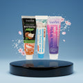 Pack Gengive & Dolcezza — 3 dentifrici ÉclatDent: i tre tubetti su un piedistallo rotondo lucido, sfondo studio blu sfumato